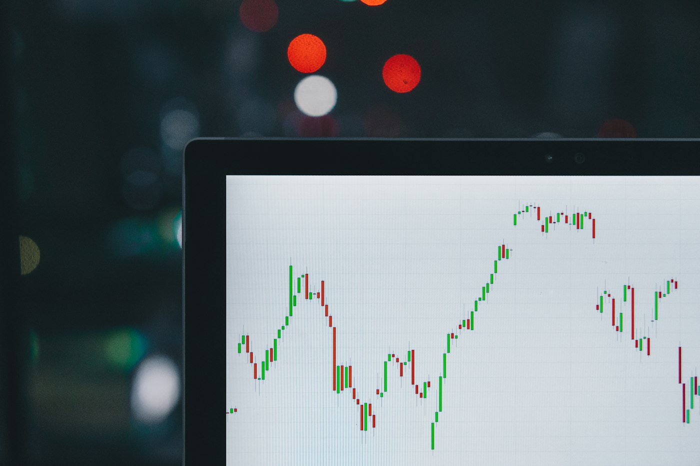 Rows of financial-market monitors displaying price charts and order-book data on a dark trading desk.